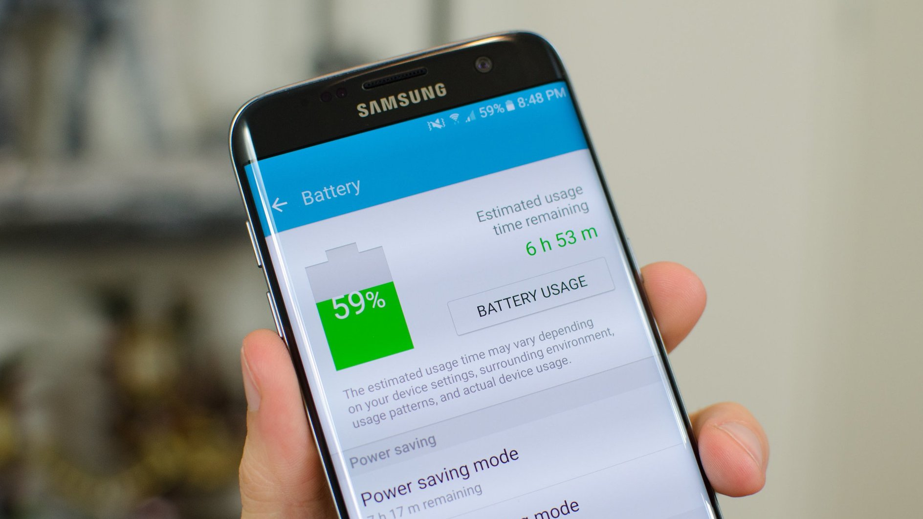 Смартфон Samsung в руке, на телефоне открыты настройки состояния аккумулятора